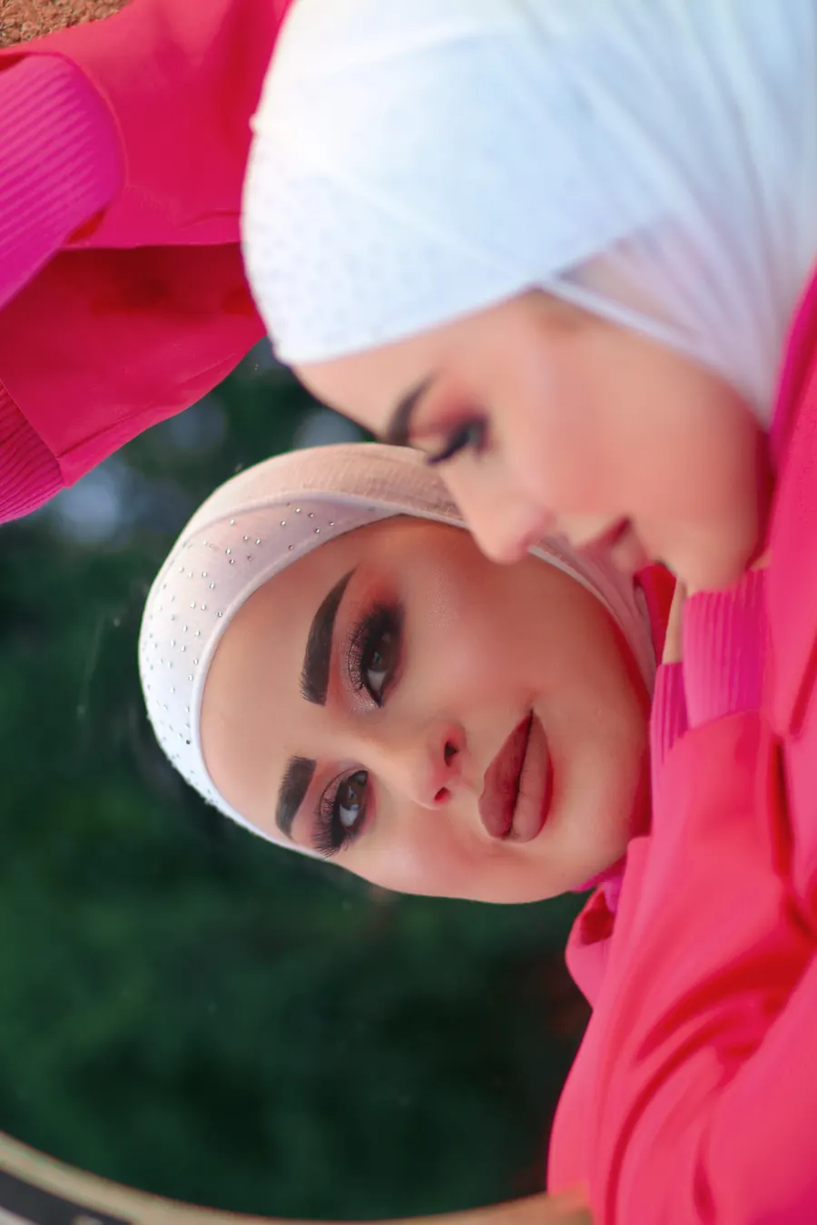 لقطة بورتريه بزاوية إبداعية عبر مرآة مائلة تُظهر انعكاسين لوجه العارضة